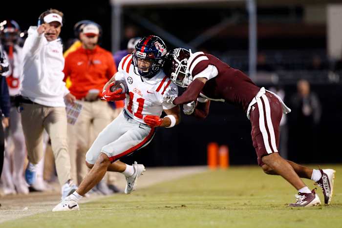 Nov 23, 2023; Starkville, Mississippi, USA; Mississippi Rebels wide receiver Jordan Watkins (11) runs after a catch for a first down as Mississippi State Bulldogs defensive back Marcus Banks (1) pushes him out of bounds during the second half at Davis Wade Stadium at Scott Field. Mandatory Credit: Petre Thomas-USA TODAY Sports